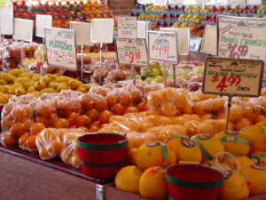 grocery store display of oranges apples and mangoes